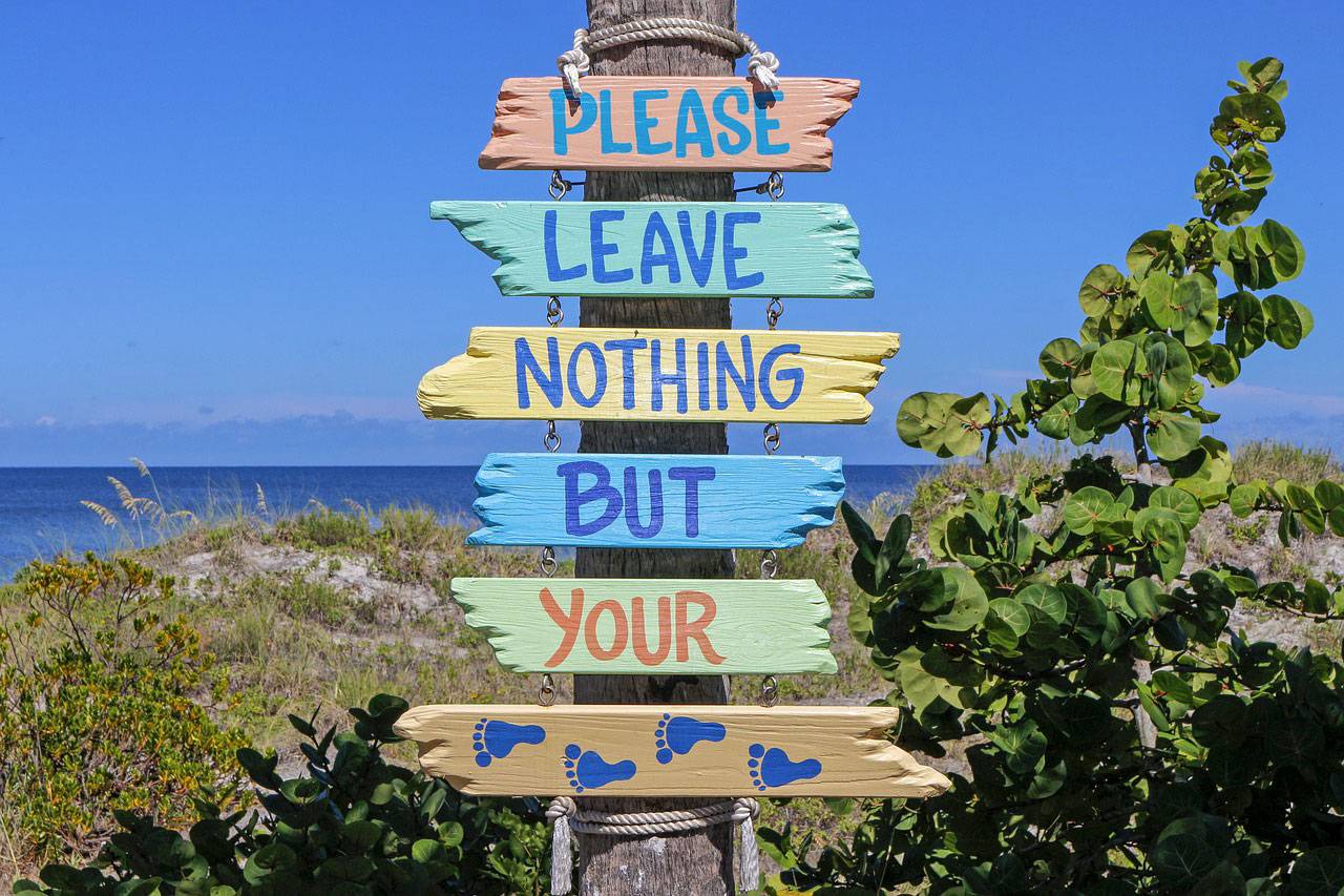 Colorful sign saying "Please leave nothing but your footprints," promoting environmental responsibility in line with Panama City's boating regulations.
