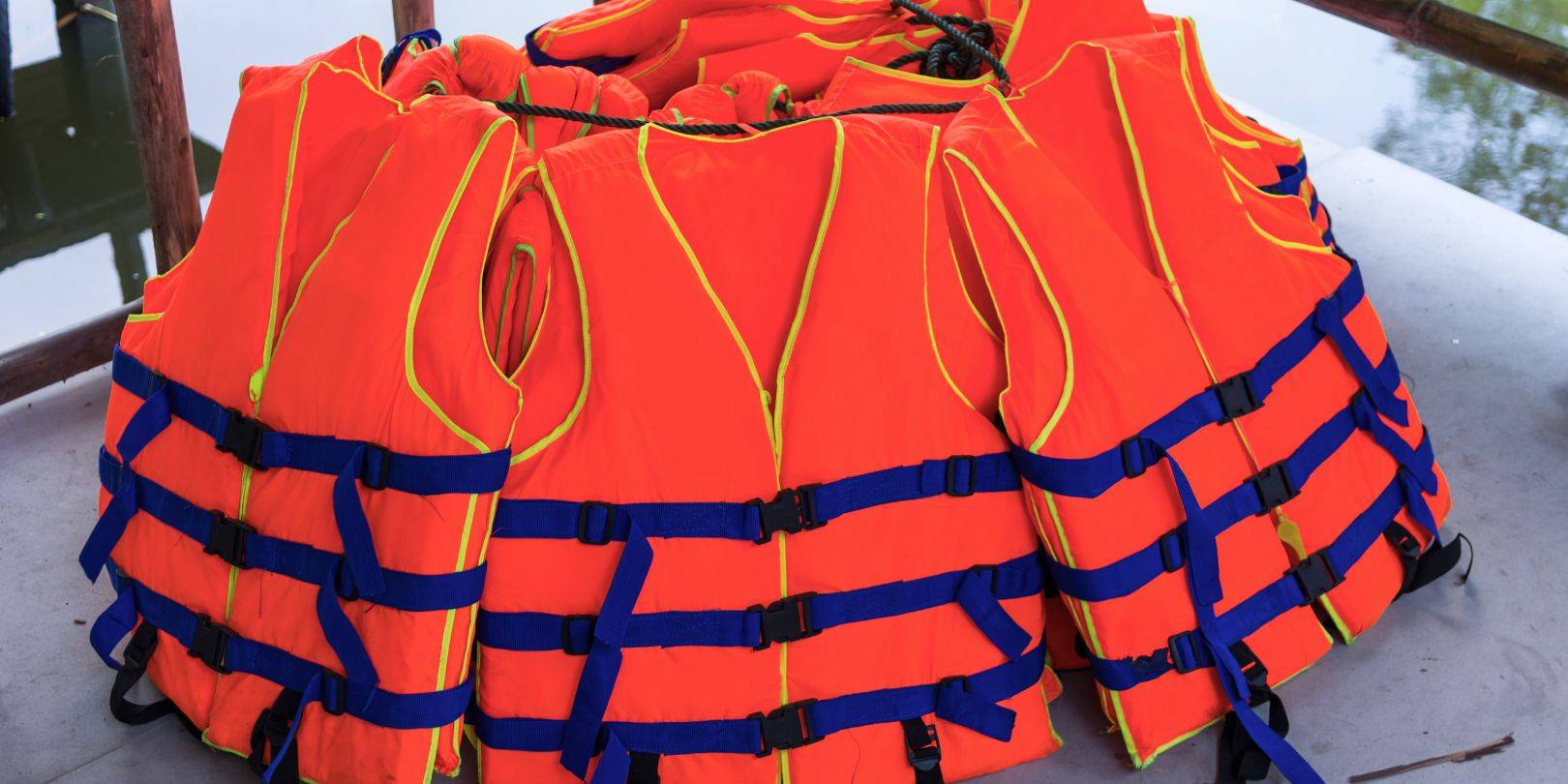 Bright orange life jackets stacked together, ensuring compliance with Panama City's boating regulations for safety on the water.