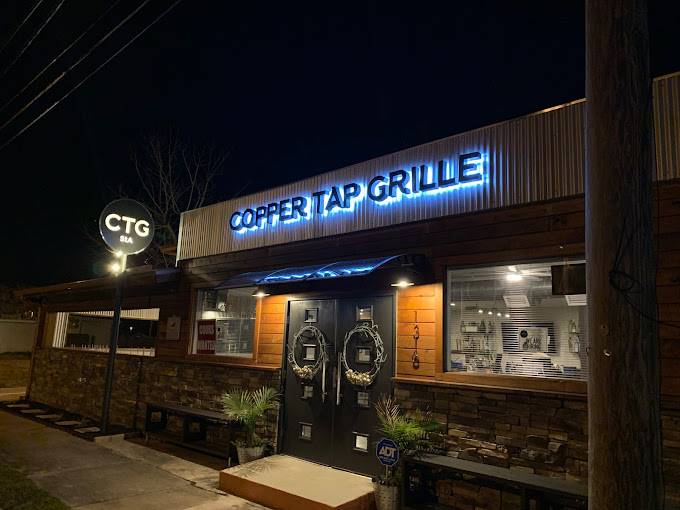 Copper Tap Grille illuminated at night, showcasing its modern and inviting exterior, representing one of Panama City's most scenic waterfront restaurants.