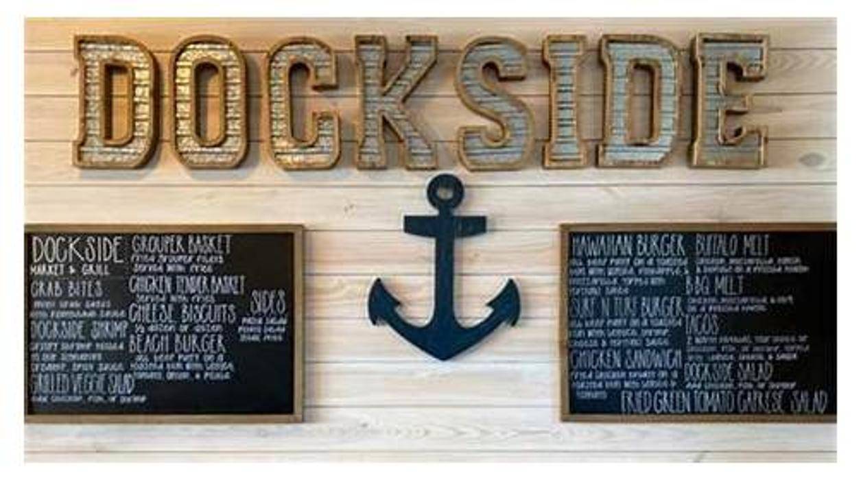Dockside Market & Grill's rustic interior with wooden 'Dockside' sign and menu boards highlights its charm among Panama City's most scenic waterfront restaurants.